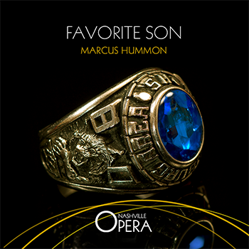 A large golden high school class ring lies on its side with a tiger and 80 engraved on it. In the center of the ring is a deep blue sapphire. Nashville Opera Favorite Son by Marcus Hummon